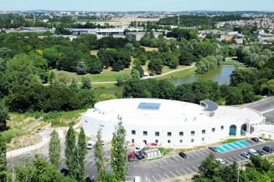 Lustre en cristal doré suspendu sous un plafond peint avec des nuances pastel de bleu et de rose.