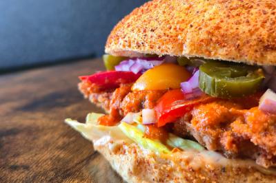 Façade d'un restaurant avec enseigne ’Burger Park’, terrasse en bois et décoration végétale.