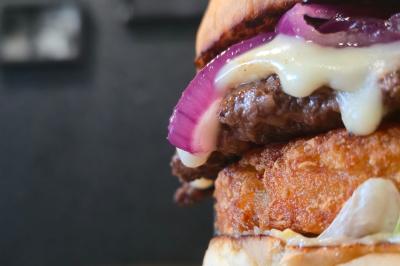 Façade d'un restaurant avec enseigne ’Burger Park’, terrasse en bois et décoration végétale.