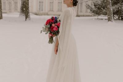 Un couple monte des marches, la mariée en robe blanche et voile, entourée d'invités élégamment vêtus.