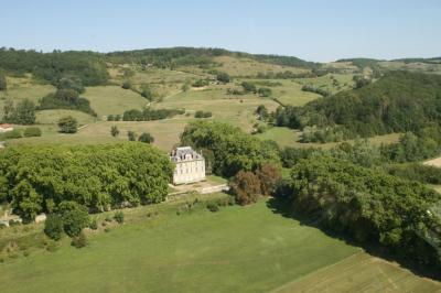 Salle de bain avec baignoire sur pieds, lavabo sur meuble en bois et murs décorés de cadres anciens.