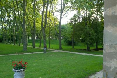 Salle de bain avec baignoire sur pieds, lavabo sur meuble en bois et murs décorés de cadres anciens.