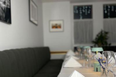 Coucher de soleil illuminant une rue bordée d'arbres et de bâtiments, avec des reflets sur le sol mouillé.