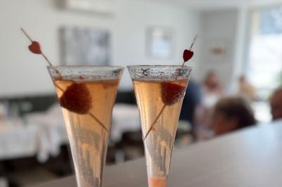 Coucher de soleil illuminant une rue bordée d'arbres et de bâtiments, avec des reflets sur le sol mouillé.