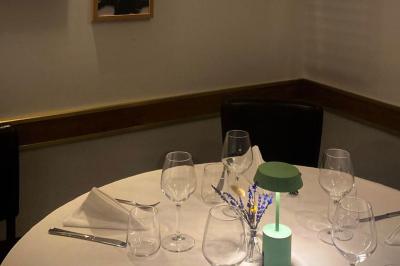 Coucher de soleil illuminant une rue bordée d'arbres et de bâtiments, avec des reflets sur le sol mouillé.