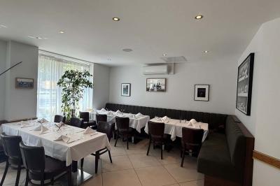 Coucher de soleil illuminant une rue bordée d'arbres et de bâtiments, avec des reflets sur le sol mouillé.