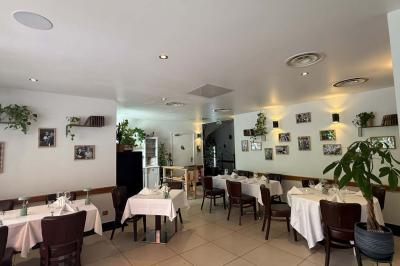 Coucher de soleil illuminant une rue bordée d'arbres et de bâtiments, avec des reflets sur le sol mouillé.