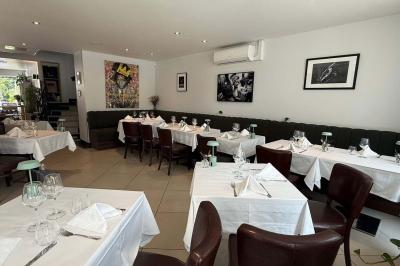 Coucher de soleil illuminant une rue bordée d'arbres et de bâtiments, avec des reflets sur le sol mouillé.