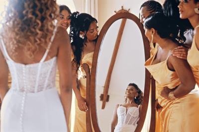Femme en robe de mariée posant près d'albums photo élégants, entourée de bijoux et d'un décor raffiné.