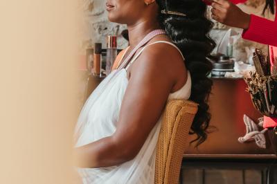 Femme en robe de mariée posant près d'albums photo élégants, entourée de bijoux et d'un décor raffiné.