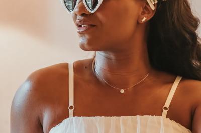 Femme en robe de mariée posant près d'albums photo élégants, entourée de bijoux et d'un décor raffiné.