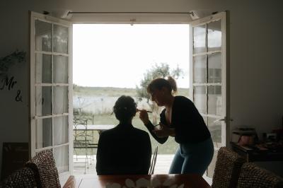 Femme en robe de mariée posant près d'albums photo élégants, entourée de bijoux et d'un décor raffiné.
