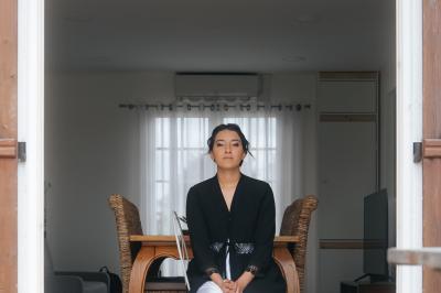 Femme en robe de mariée posant près d'albums photo élégants, entourée de bijoux et d'un décor raffiné.