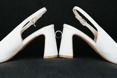 Femme en robe de mariée posant près d'albums photo élégants, entourée de bijoux et d'un décor raffiné.