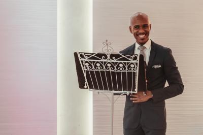 Femme en robe de mariée posant près d'albums photo élégants, entourée de bijoux et d'un décor raffiné.