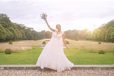 Femme en robe de mariée posant près d'albums photo élégants, entourée de bijoux et d'un décor raffiné.