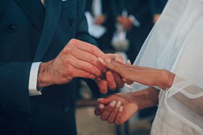 Femme en robe de mariée posant près d'albums photo élégants, entourée de bijoux et d'un décor raffiné.
