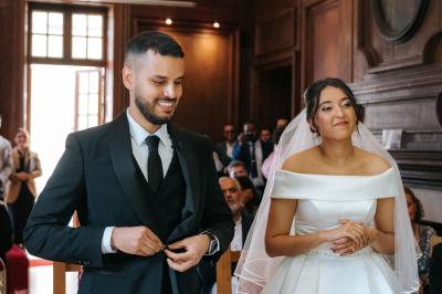 Femme en robe de mariée posant près d'albums photo élégants, entourée de bijoux et d'un décor raffiné.