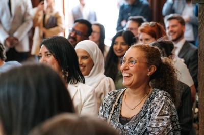 Femme en robe de mariée posant près d'albums photo élégants, entourée de bijoux et d'un décor raffiné.