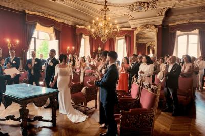 Femme en robe de mariée posant près d'albums photo élégants, entourée de bijoux et d'un décor raffiné.