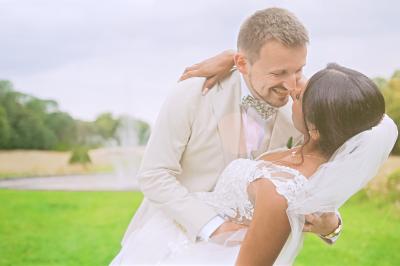 Femme en robe de mariée posant près d'albums photo élégants, entourée de bijoux et d'un décor raffiné.