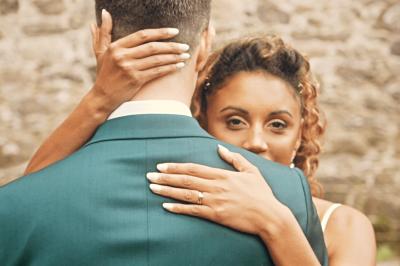 Femme en robe de mariée posant près d'albums photo élégants, entourée de bijoux et d'un décor raffiné.