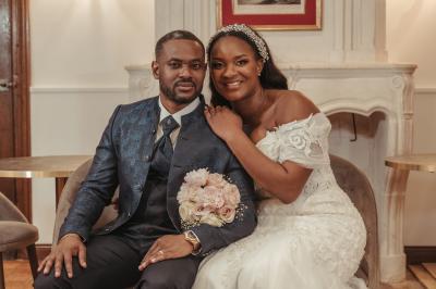 Femme en robe de mariée posant près d'albums photo élégants, entourée de bijoux et d'un décor raffiné.