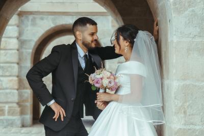 Femme en robe de mariée posant près d'albums photo élégants, entourée de bijoux et d'un décor raffiné.