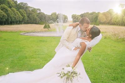Femme en robe de mariée posant près d'albums photo élégants, entourée de bijoux et d'un décor raffiné.