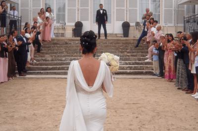 Femme en robe de mariée posant près d'albums photo élégants, entourée de bijoux et d'un décor raffiné.