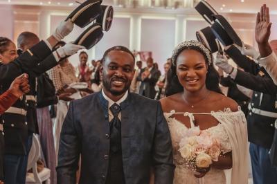Femme en robe de mariée posant près d'albums photo élégants, entourée de bijoux et d'un décor raffiné.