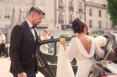 Femme en robe de mariée posant près d'albums photo élégants, entourée de bijoux et d'un décor raffiné.