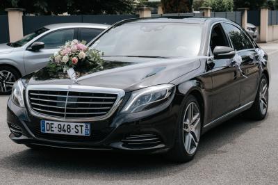 Femme en robe de mariée posant près d'albums photo élégants, entourée de bijoux et d'un décor raffiné.
