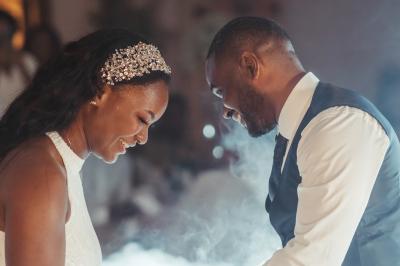 Femme en robe de mariée posant près d'albums photo élégants, entourée de bijoux et d'un décor raffiné.