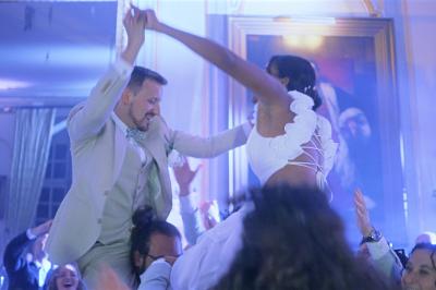 Femme en robe de mariée posant près d'albums photo élégants, entourée de bijoux et d'un décor raffiné.