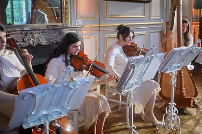 Femme en robe de mariée posant près d'albums photo élégants, entourée de bijoux et d'un décor raffiné.