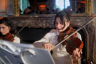 Femme en robe de mariée posant près d'albums photo élégants, entourée de bijoux et d'un décor raffiné.