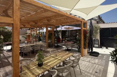 Salle de restaurant lumineuse avec tables dressées, chaises confortables et grandes baies vitrées laissant entrer la lumière…