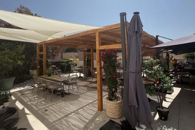 Salle de restaurant lumineuse avec tables dressées, chaises confortables et grandes baies vitrées laissant entrer la lumière…