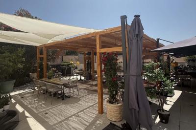 Salle de restaurant élégante avec table dressée, chaises vertes, bar en arrière-plan et décoration florale.