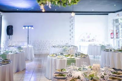 Dessert composé de crème fouettée, framboises fraîches, pétales de fleurs et feuilles de menthe sur une assiette noire.