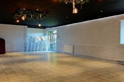 Dessert composé de crème fouettée, framboises fraîches, pétales de fleurs et feuilles de menthe sur une assiette noire.