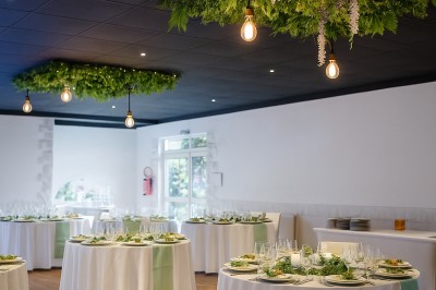 Gâteau décoré de glaçage caramel, éléments en chocolat, framboises et feuilles de menthe sur une assiette blanche.
