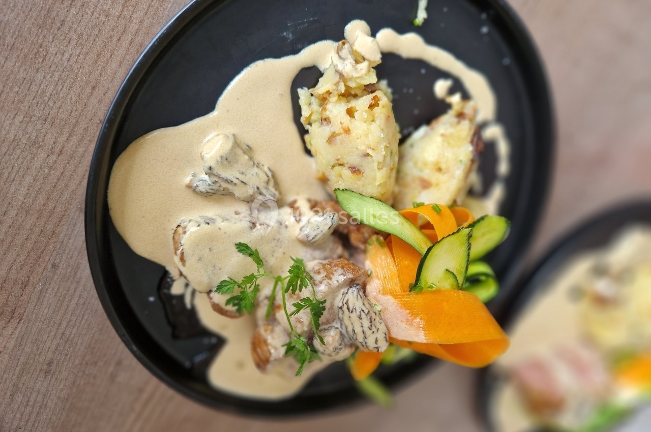 Assiette de viande nappée de sauce crémeuse aux morilles, accompagnée de légumes et d'une purée gratinée.