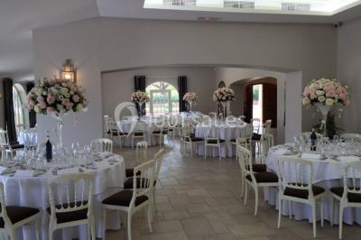Allée rouge menant à une cérémonie en plein air, entourée de chaises blanches et de jardins verdoyants.