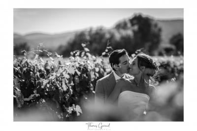 Allée rouge menant à une cérémonie en plein air, entourée de chaises blanches et de jardins verdoyants.