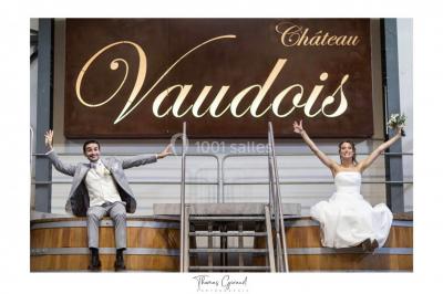 Allée rouge menant à une cérémonie en plein air, entourée de chaises blanches et de jardins verdoyants.