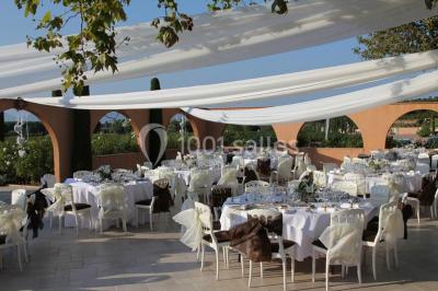 Allée rouge menant à une cérémonie en plein air, entourée de chaises blanches et de jardins verdoyants.