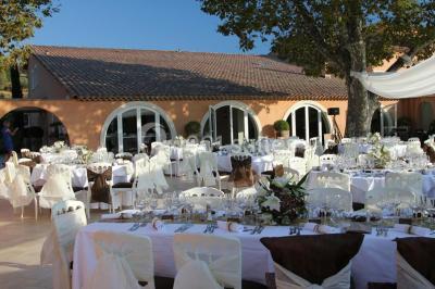 Allée rouge menant à une cérémonie en plein air, entourée de chaises blanches et de jardins verdoyants.