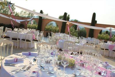 Allée rouge menant à une cérémonie en plein air, entourée de chaises blanches et de jardins verdoyants.